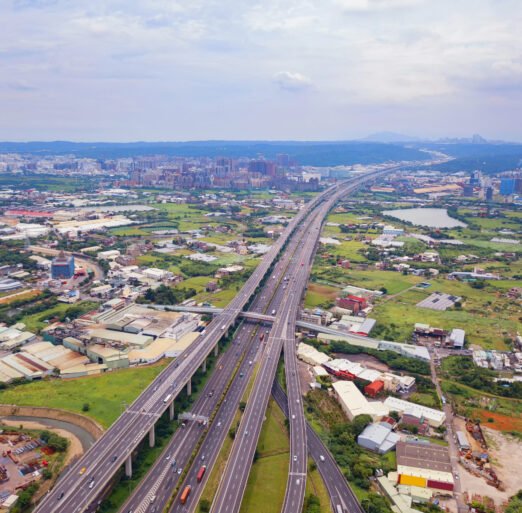Aerial view of cars driving on highway junctions. Bridge roads with green garden and trees in connection of architecture concept. Top view. Urban city, Taipei, Taiwan.